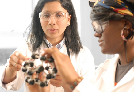 two scientists looking at an element as a 3d model