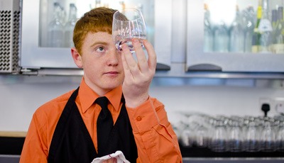 Hospitality student shining glass